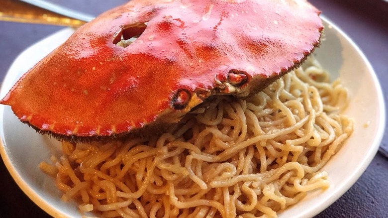 Dungeness crab atop a plate of creamy garlic noodles.