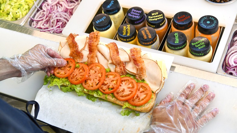 Subway employee building sub behind the counter