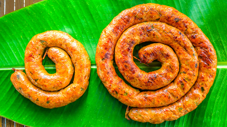 Two coils of Sai Uoa sausage sitting on a banana leaf
