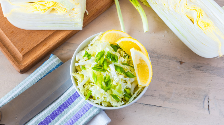 A bowl of cabbage with three lemon slices