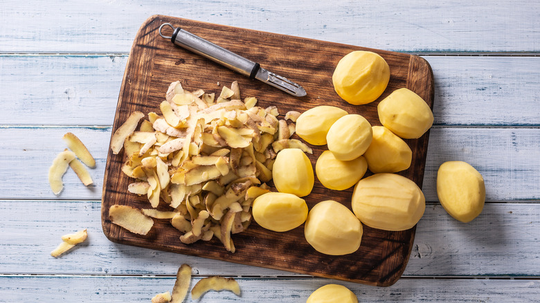 An illustrative image showing potato peels on a wooden board.