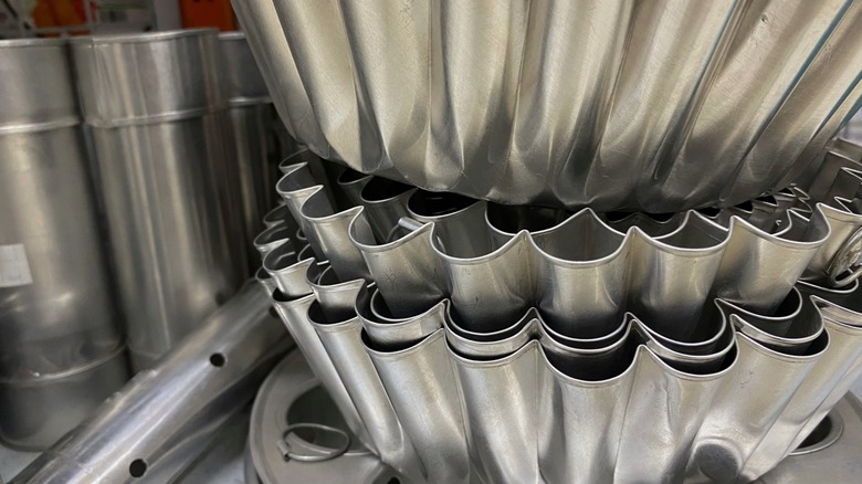 Haphazardly stacked cake pans in a cabinet