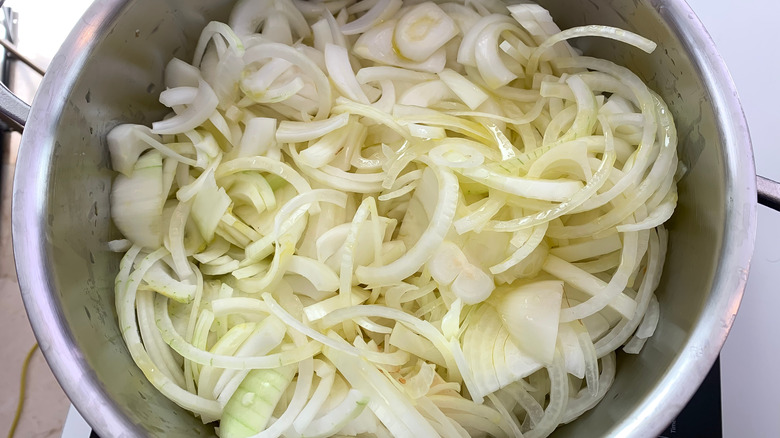 A large pot of sliced onions is photographed from overhead.