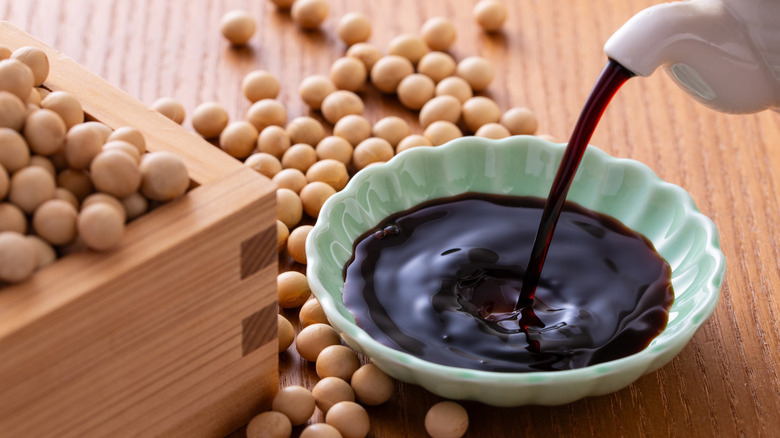 pouring soy sauce into a small bowl