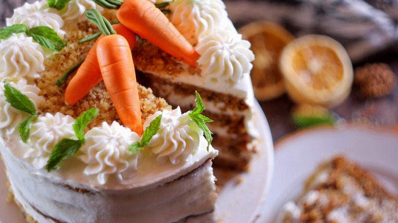 a carrot cake decorated with mint and fondant carrots