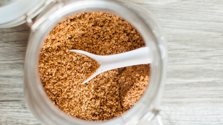 A jar of brown sugar with a spoon