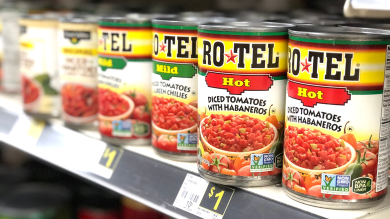Cans of Rotel on a store shelf.