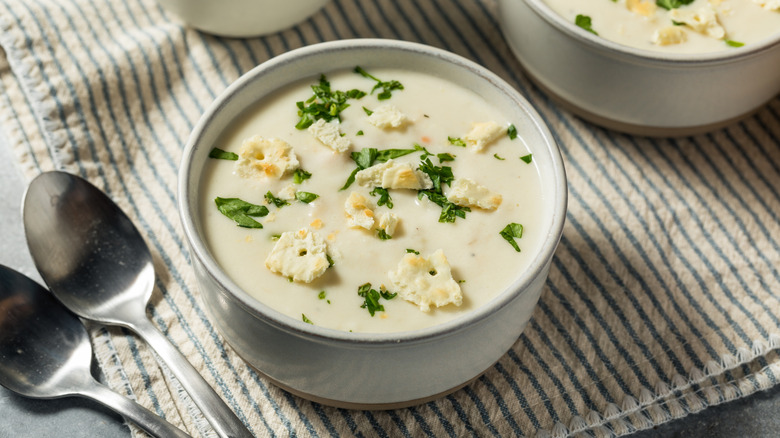 Bowl of clam chowder with spoons on the side