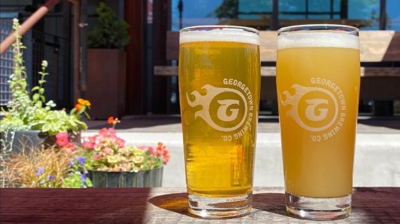 Two different beers in pints sitting on the outdoor patio at Georgetown Brewing Co in Seattle.