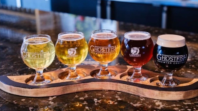 A flight of different beers lined up on a board for tasting at Ghostfish Brewing in Seattle.