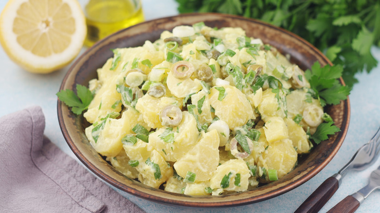 Bowl of potato salad with side of lemon and olive oil
