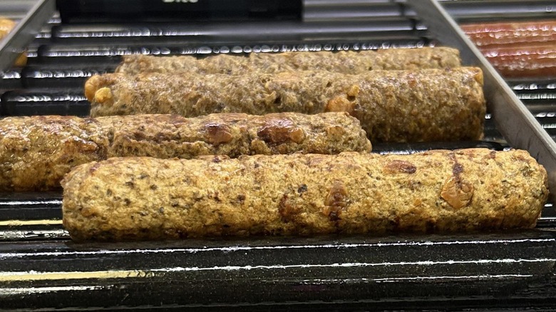 Cheeseburger Roller Bites from 7-Eleven sadly rotating on their roller