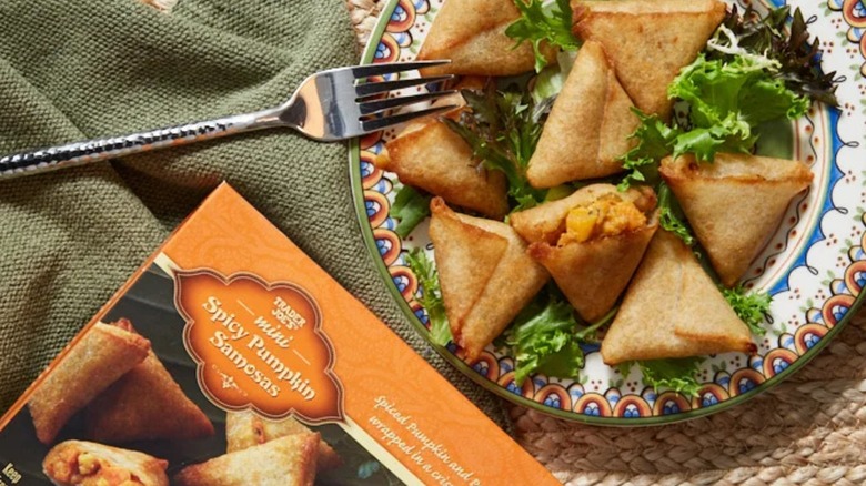 a box of TJ's pumpkin samosas next to a plate of them