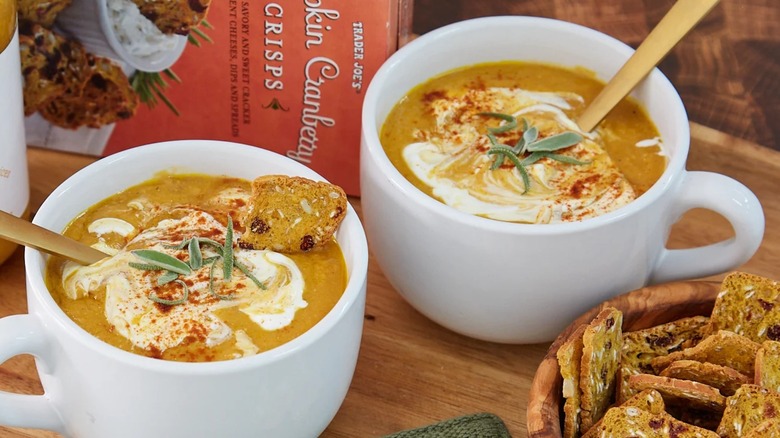 A box of Trader Joe's pumpkin cranberry crisps with one in a bowl of soup