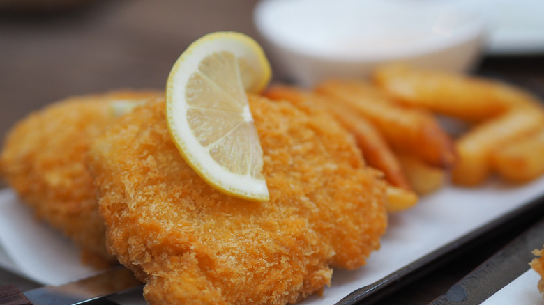battered and baked cod fillets with a lemon wedge on a plate