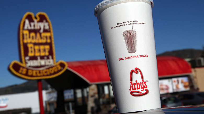 Arby's drink in forground, arby's sign in background