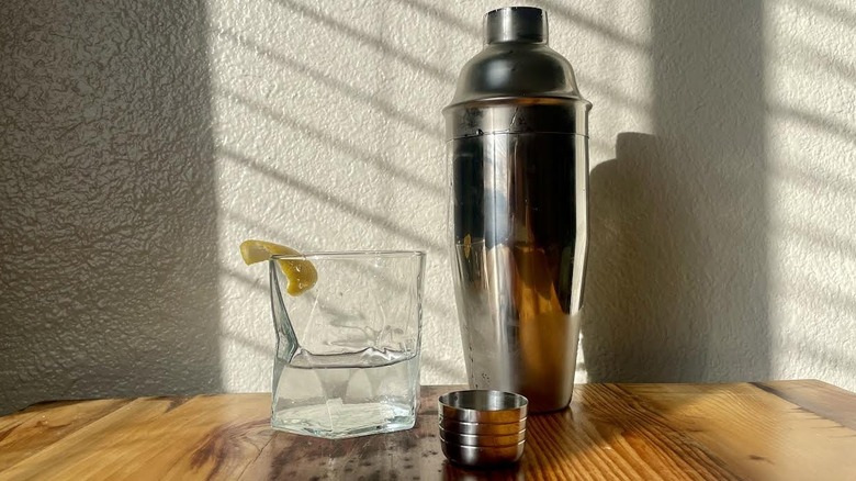 Classic martini with a lemon swath and a cocktail shaker.