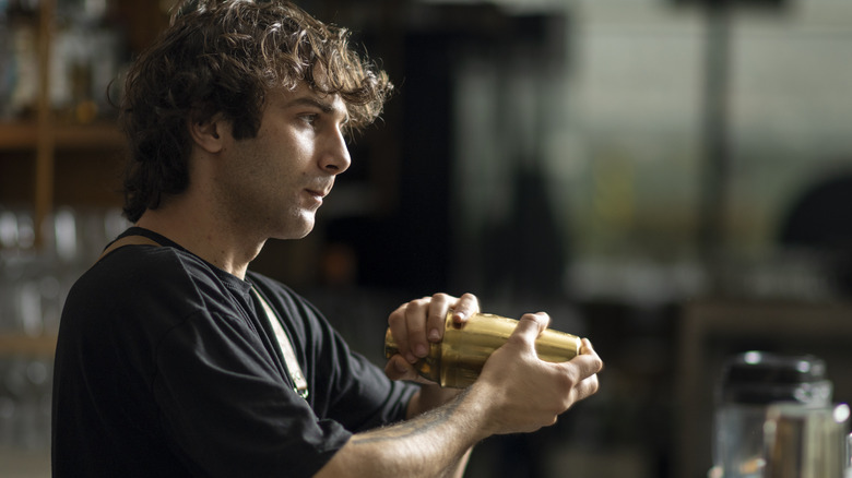 Barista shaking a cocktail shaker.