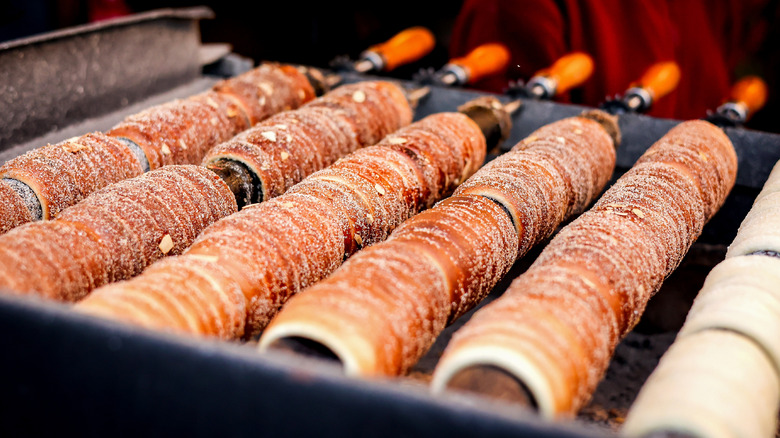 Trdelníks cooking on a rotisserie