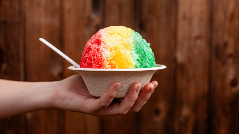 Hand holding a bowl of multicolored Hawaiian shaved ice