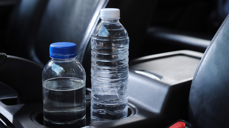 A bottle of water sits in a car cupholder.