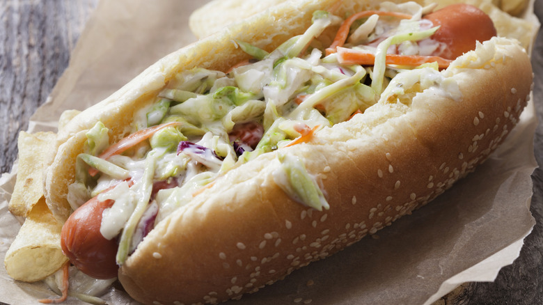 Hot dog on a sesame seed bun topped with coleslaw