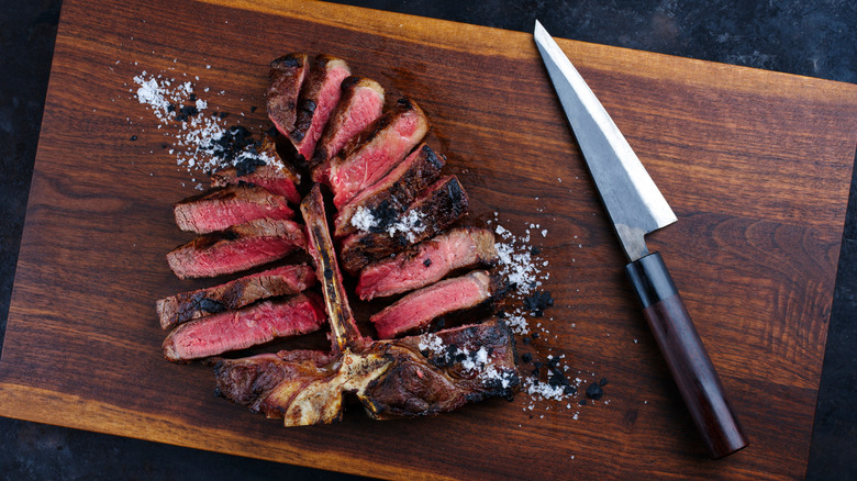 A drop down view of a non-serrated steak knife and steak cut into slices