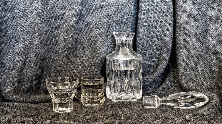 A sophisticated decanter filled with vodka alongside glasses of the spirit.