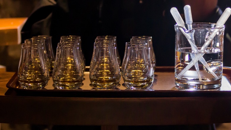 Rows of whiskey glasses with glass pipettes