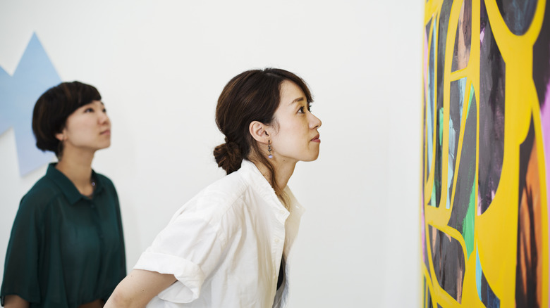 Two people looking engaged, while appreciating a colorful piece of art