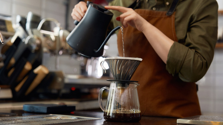 Barista pouring water into a filter for pour-over coffee