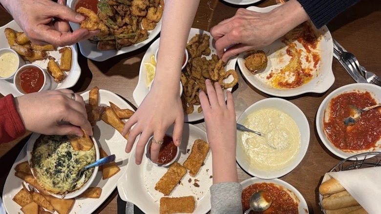 Hands over a table of food