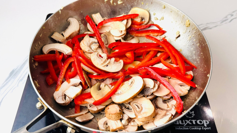 Sliced bell pepper and mushrooms in pan