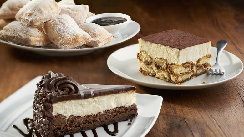 Various Olive Garden desserts on white plates