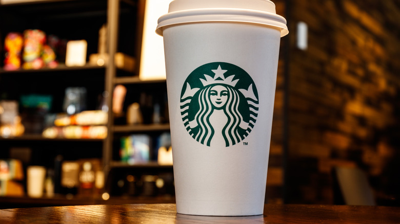 To-go coffee cup with the Starbucks logo sitting on a table