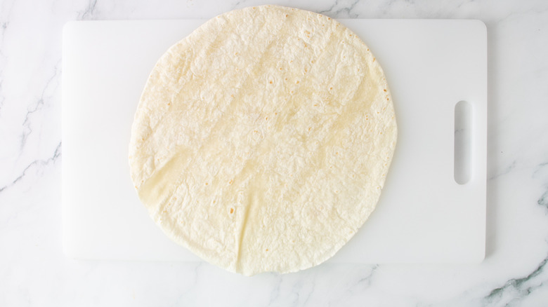 flour tortilla on a white plastic board