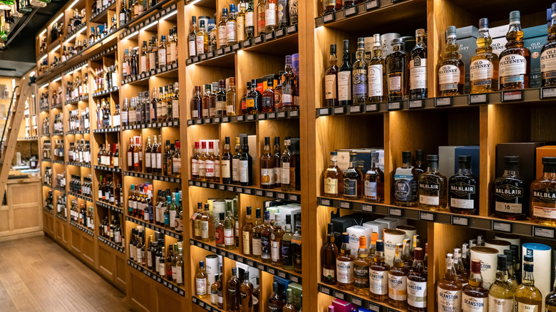 A large display of alcohol varieties line store shelves.