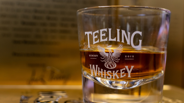 Glass with Teeling logo and whiskey inside