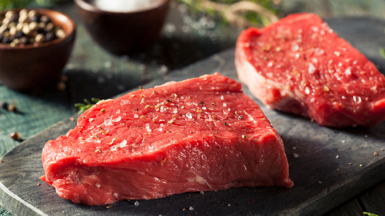Raw sirloin steak on a cutting board.