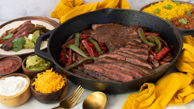 Side shot of steak fajita in a cast iron skillet