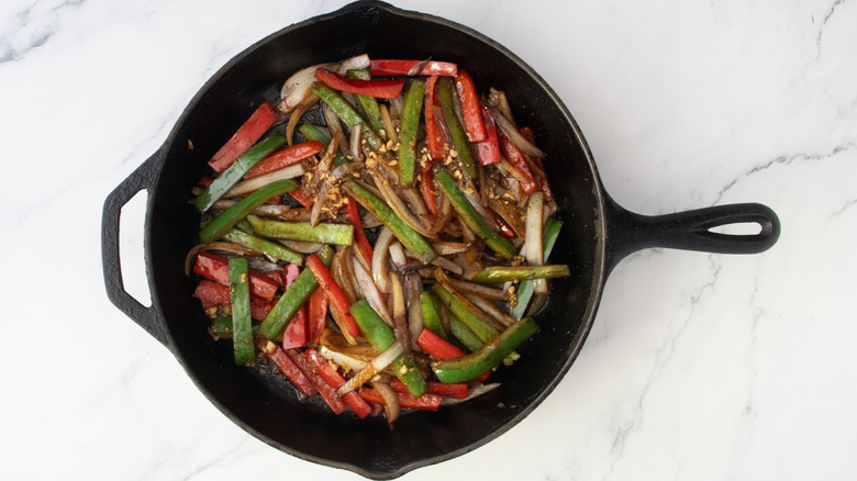 Sauteed peppers and onions drizzle with carne asada marinade.