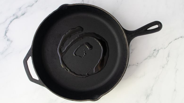 Olive oil drizzled in a large cast iron skillet