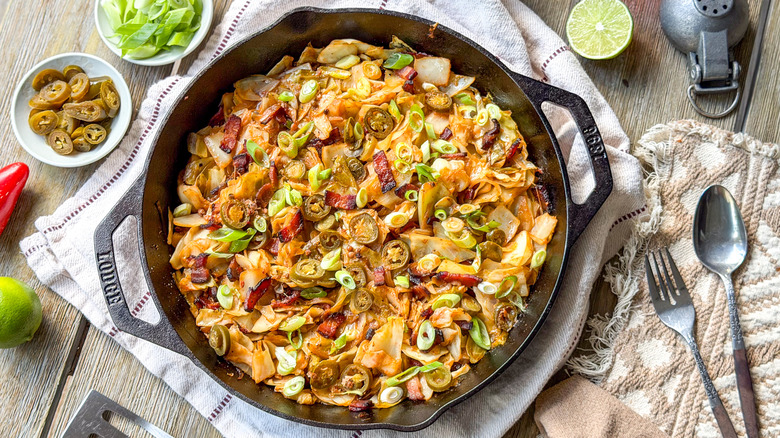 Skillet cowboy cabbage on table with garnishes