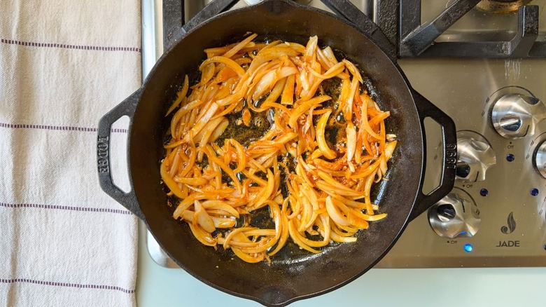Sauteed onion and spices in cast iron skillet on stovetop
