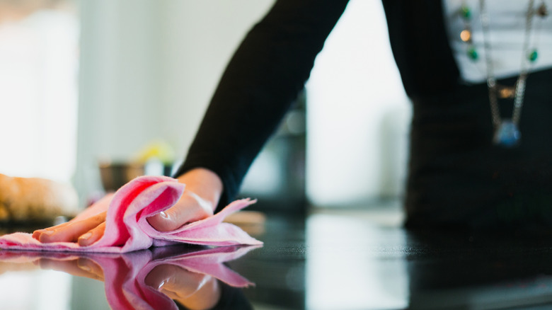 Close-up of a woman cleaning kitchen counter.