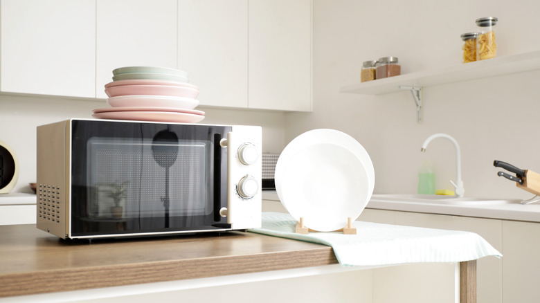 A spotless kitchen with a microwave on top of the counter