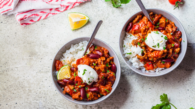 Two bowls of chili with sour cream