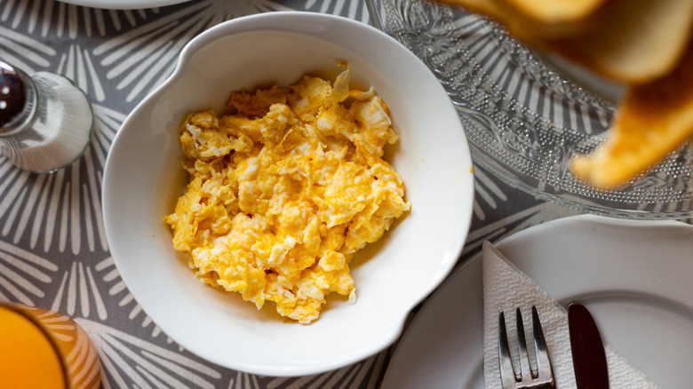 Fluffy scrambled eggs on a white plate.