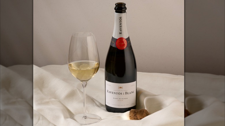 A bottle and glass of Raventos i Blanc Blanc de Blancs on a table
