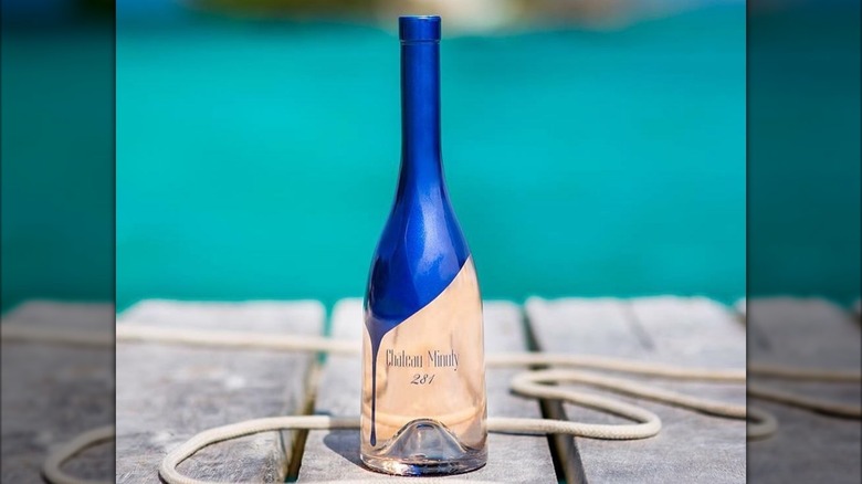 A bottle of Château Minuty 281 on a wooden dock